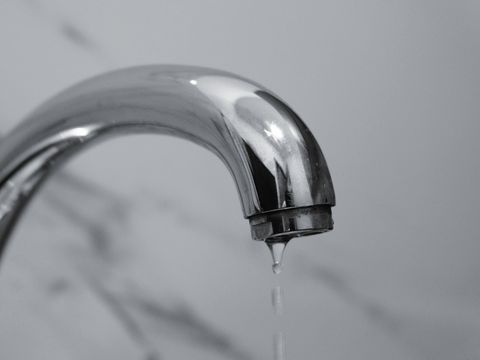 A chrome tap with a drip falling from the spout