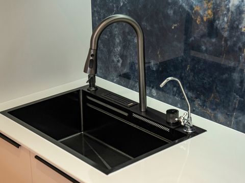 A pull-down kitchen mixer tap over a black sink