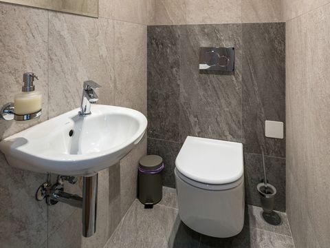 A wall-hung toilet and basin in a small bathroom